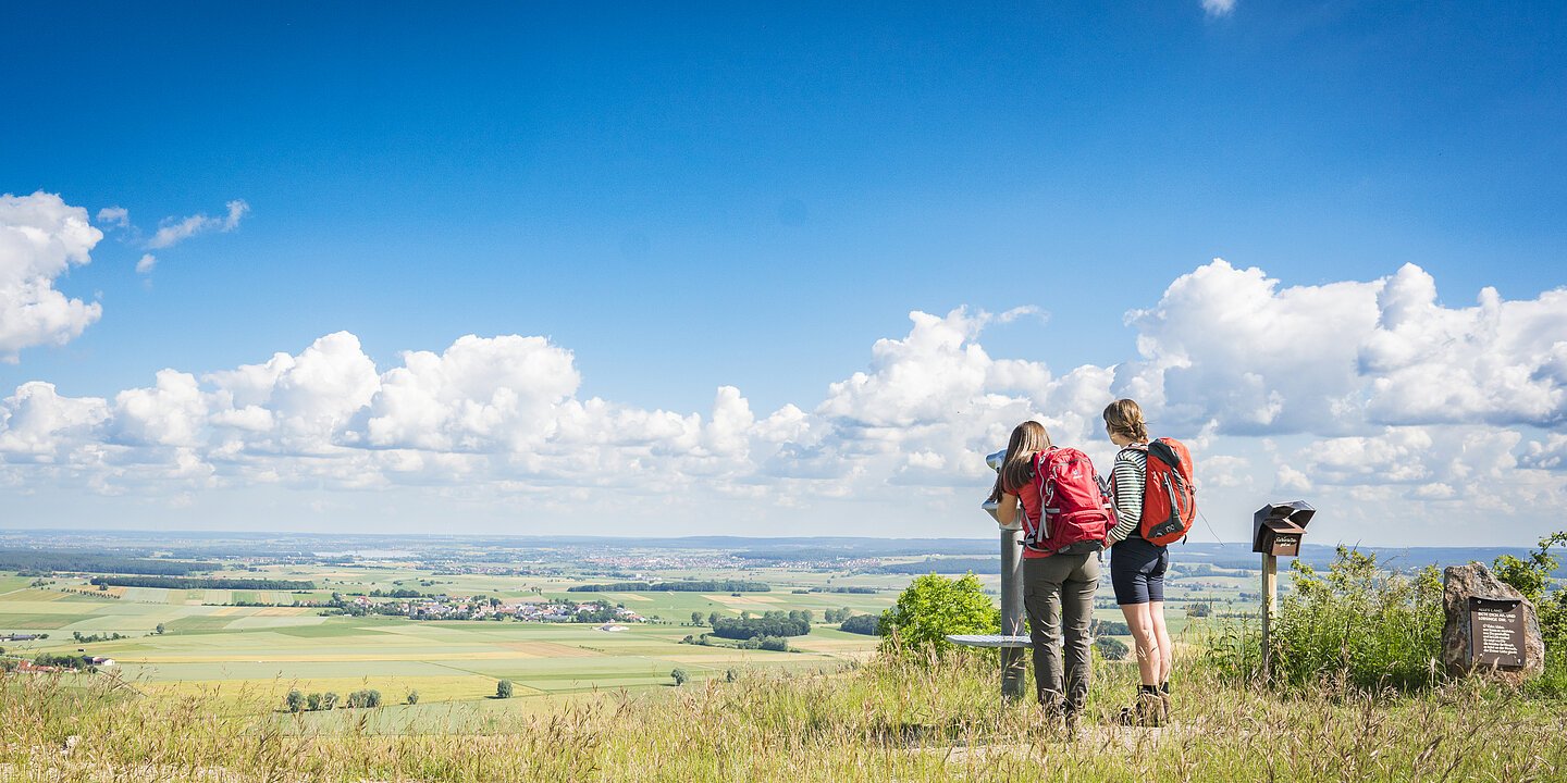 Zwei Wanderinnen mit Rucksack schauen in ein Fernglas in die Weite. Naturschutzgebiet Gelber Berg.
